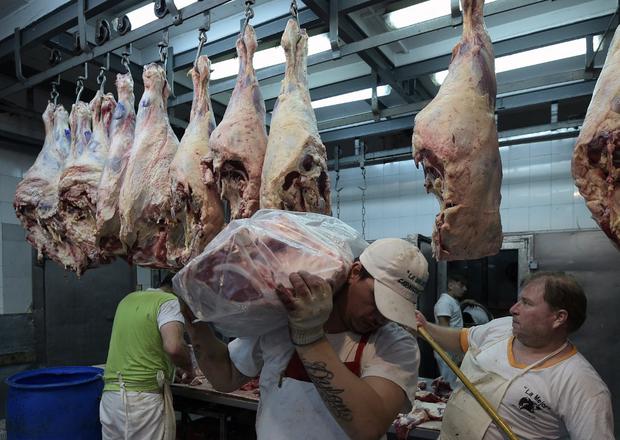 En la foto se aprecia a trabajadores llevando carne de res en una carnicería en Buenos Aires, Argentina. (JUAN MABROMATA / AFP)