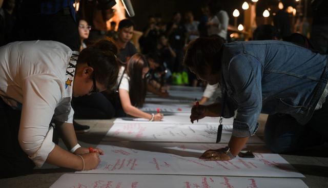 Familias de las víctimas escribieron mensajes en honor a sus seres queridos en el frontis del centro comercial. (AFP).