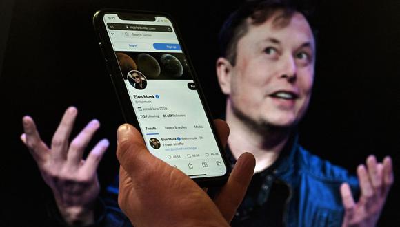 La pantalla de un teléfono muestra la cuenta de Twitter de Elon Musk con una foto de él en el fondo, en Washington, DC. (Foto de Olivier DOULIERY / AFP)
