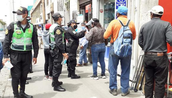 Policías distribuyeron mascarillas a quienes formaban cola en el Banco de la Nación.