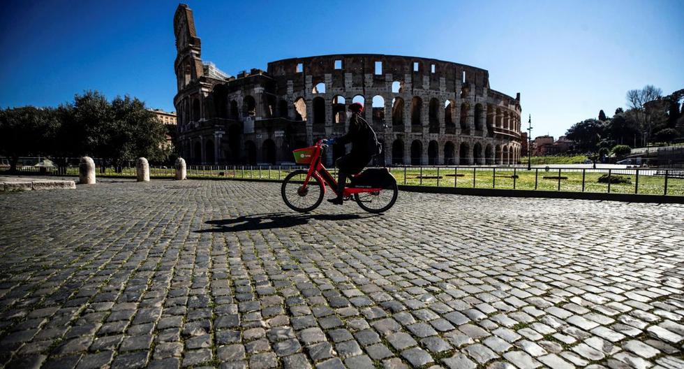 Una persona monta en bicicleta ante el Coliseo romano durante el nuevo confinamiento, en Roma, el 15 de marzo de 2021. (EFE/EPA/ANGELO CARCONI).