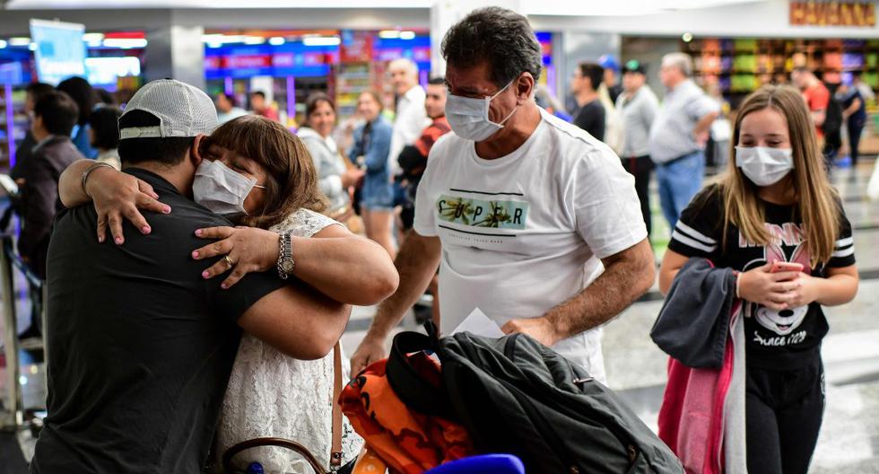 Pasajeros con mascarilla como medida preventiva contra la propagación del coronavirus COVID-19 arriban al Aeropuerto Internacional de Ezeiza en Buenos Aires. (AFP / Ronaldo SCHEMIDT).