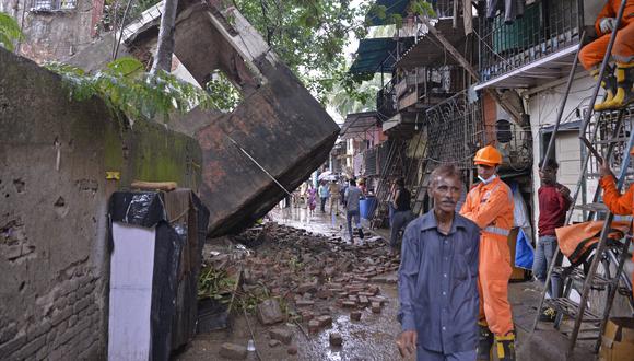 Los equipos de rescate se paran junto al edificio derrumbado en Mumbai el 28 de junio de 2022.  (Foto de Indranil MUKHERJEE / AFP)