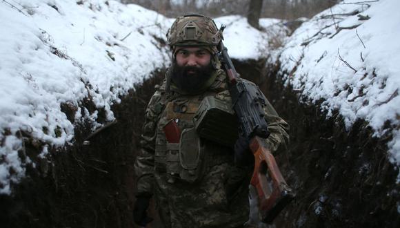 Un militar de las Fuerzas Militares de Ucrania posa con sus armas en una trinchera en primera línea con los separatistas respaldados por Rusia cerca de la aldea de Zolote, en la región oriental de Lugansk, el 21 de enero de 2022. (Foto de Anatolii STEPANOV / AFP)