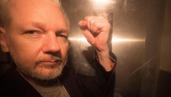 El fundador de Wikileaks, Julian Assange, saluda a los fotógrafos mientras abandona en un vehículo policial en 2019. (EFE/ Neil Hall)