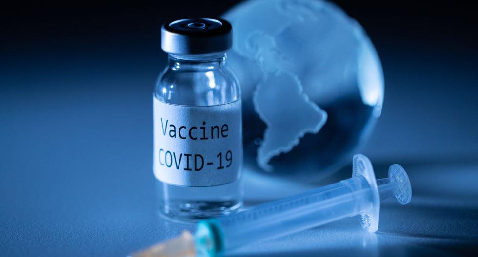 Una fotografía ilustrativa tomada el 19 de noviembre de 2020 muestra un vial con la etiqueta adhesiva de la vacuna coronavirus Covid-19, una jeringa y un globo terráqueo. (Foto de JOEL SAGET / AFP).