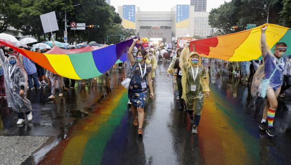 Activistas por los derechos LGBT llevan una gran pancarta de arcoíris mientras marchan frente al edificio comercial Taipei 101 durante el Desfile del Orgullo Gay en Taipei el 29 de octubre de 2022. (Foto de Jameson WU / AFP)