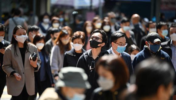 La gente usa máscaras en una calle de Hong Kong el 27 de febrero de 2023. (Foto de Peter PARQUES / AFP)