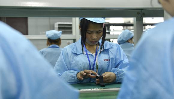 Esta imagen muestra a trabajadores ensamblando una alternativa local más económica al Apple Watch en una fábrica que produce miles todos los días en Shenzhen, en el sur de China. (Foto: AFP)