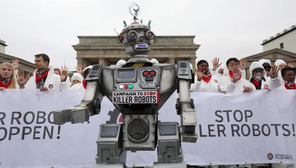 La gente participa en una manifestación como parte de la campaña "Stop Killer Robots" organizada por la ONG alemana "Facing Finance" para prohibir lo que llaman robots asesinos el 21 de marzo de 2019 frente a la Puerta de Brandenburgo en Berlín. (Foto de Wolfgang Kumm / dpa / AFP)