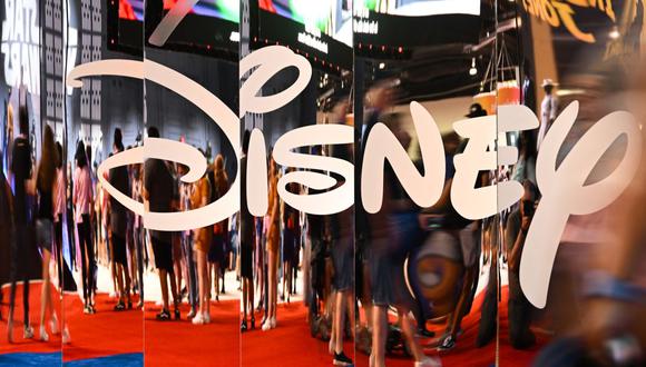 Los asistentes se reflejan en el logotipo de Disney+ durante la Expo D23 de Walt Disney en Anaheim, California, el 9 de septiembre de 2022. (Foto de Patrick T. FALLON / AFP)