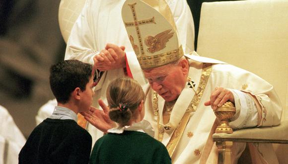 El Papa Juan Pablo II hablando con dos niños después de celebrar la Misa de Año Nuevo en la Basílica de San Pedro en el Vaticano.  (Foto de GERARD JULIEN / AFP)
