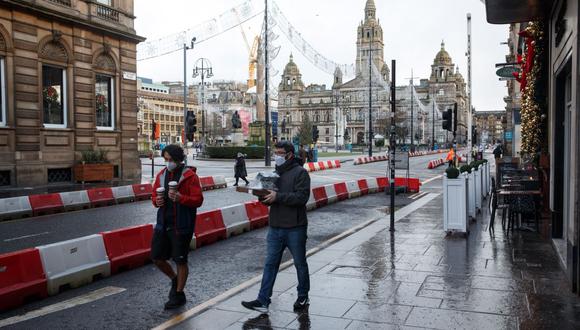 Dos hombres llevan comida para llevar en George Square, durante el primer día en el nuevo bloqueo en Glasgow, Escocia, Reino Unido. (EFE/Robert Perry).
