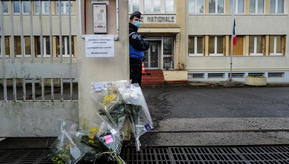 Un gendarme francés monta guardia junto a las flores colocadas en la entrada de la gendarmería en Ambert, en el centro de Francia, el 23 de diciembre de 2020, después de que tres gendarmes fueron asesinados. (Foto: Olivier CHASSIGNOLE / AFP)