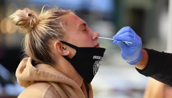 Un trabajador médico toma una muestra de un hisopo nasal de un estudiante para realizar una prueba de COVID-19 en el sitio de prueba emergente de atención de urgencia de Brooklyn Health Medical Alliance . (Angela Weiss/AFP).