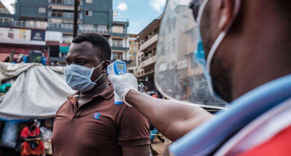 Un voluntario de la Cruz Roja mide la temperatura de un hombre antes de que se le permita ingresar al mercado de Nakasero en Kampala, Uganda, en medio de los esfuerzos por contener el coronavirus Covid-19. (Foto: Sumy Sadurni / AFP)