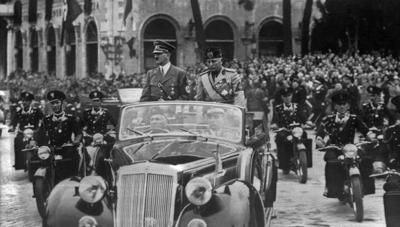 Una fotografía tomada en septiembre de 1937, en Munich, muestra a Adolf Hitler  en un automóvil con el dictador italiano Benito Mussolini mientras la multitud hace el saludo fascista.  (Foto por SNEP / AFP)
