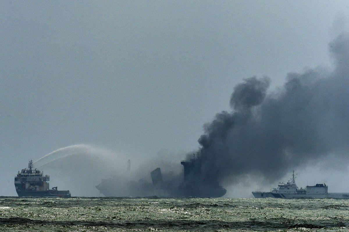 Un barco de la Armada de Sri Lanka intenta apagar el fuego mientras el humo sale del buque portacontenedores registrado en Singapur "MV X-Press Pearl". (ISHARA S. KODIKARA / AFP).