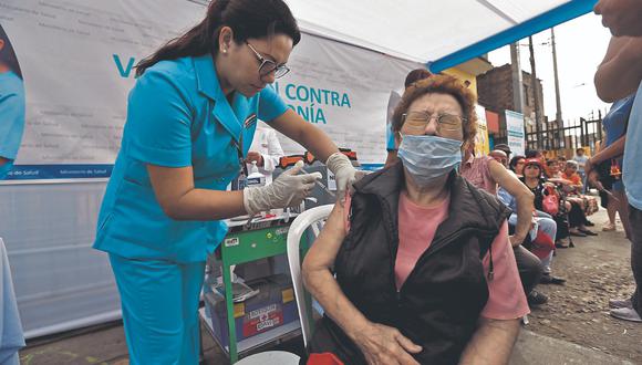 Una mujer, protegida con una mascarilla, recibiendo una vacuna, que es puesta por una especialista en la salud. | Foto: GEC