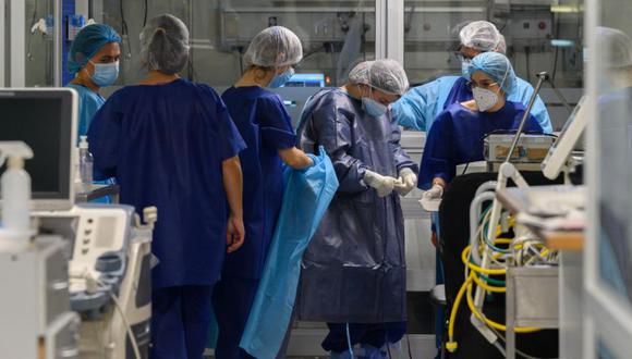Trabajadores de la salud se preparan para atender a un paciente en una Unidad de Cuidados Intensivos (UCI) Covid-19, en un hospital privado de Montevideo, el 4 de junio de 2021. (Foto de Pablo PORCIUNCULA / AFP)