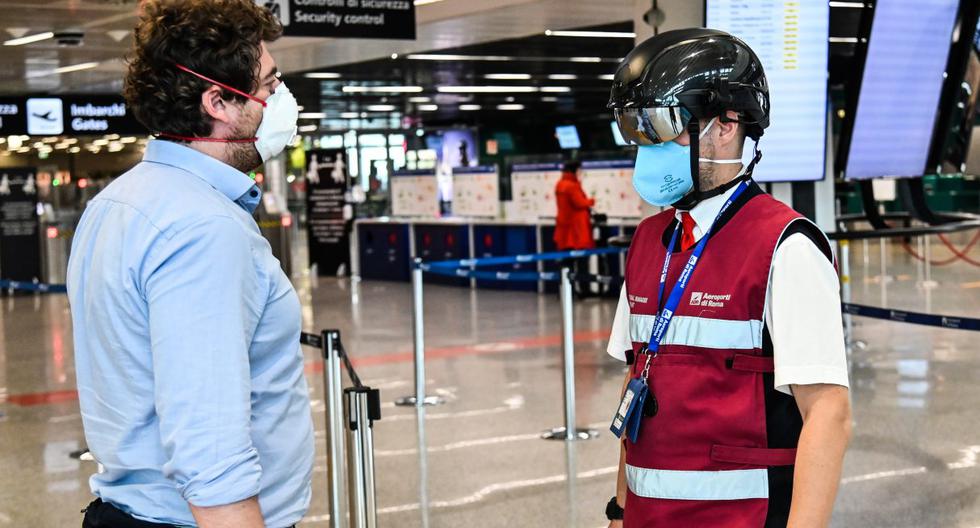 Imagen referencial. Un empleado del aeropuerto de Fiumicino en Roma es visto utilizando en medio de la pandemia del coronavirus un termoescáner portátil el pasado 5 de mayo de 2020. (ANDREAS SOLARO / AFP).