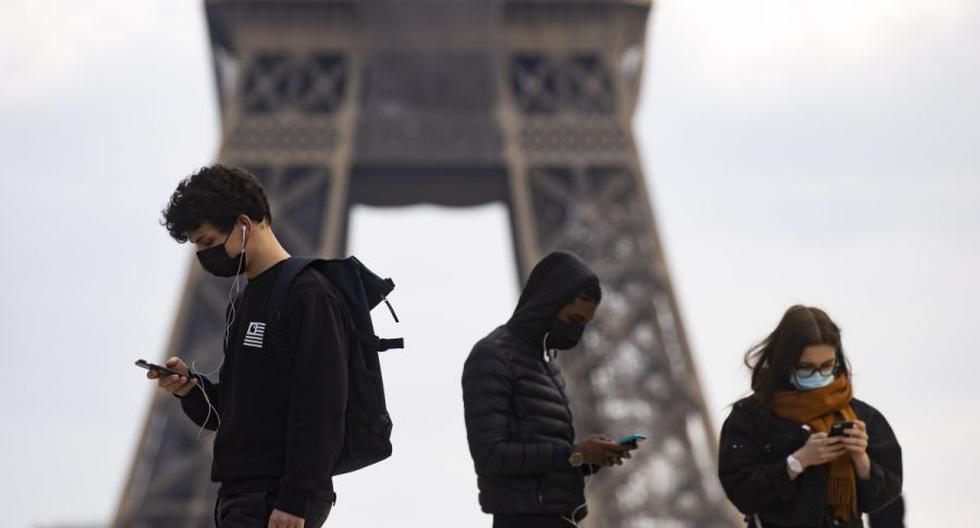 Peatones con mascarillas caminan cerca de la Torre Eiffel en París, Francia, 26 de febrero de 2021. (EFE/EPA/IAN LANGSDON).
