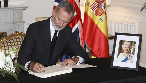 El rey Felipe VI firma en el libro de condolencias por el fallecimiento de la reina Isabel II, durante la visita hoy viernes de los monarcas españoles a la residencia del embajador del Reino Unido en España, Hugh Elliott.  (Foto: EFE/Casa de SM El Rey/JOSÉ JIMÉNEZ)