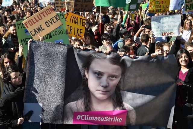 Personas y estudiantes sostienen pancartas y pancartas que muestran a la activista política sueca de 16 años Greta Thunberg, que busca detener el calentamiento global y el cambio climático, mientras participan en una protesta contra el calentamiento global en el centro de Roma el 15 de marzo de 2019. Foto de Andreas SOLARO / AFP)
