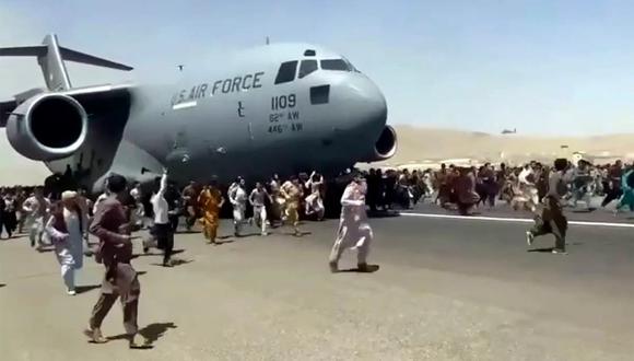Cientos de personas corren junto a un avión de transporte C-17 de la Fuerza Aérea de EE. UU. mientras avanza por una pista del aeropuerto internacional de Kabul, Afganistán, el lunes 16 de agosto del 2021. (CGU).