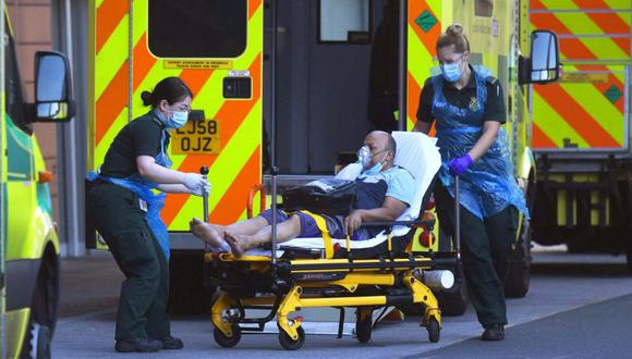 Un equipo de ambulancia usa PPE (Equipo de Protección Personal) mientras atiende a un paciente en el Royal London Hospital en Londres, Gran Bretaña. (EFE/NEIL HALL).