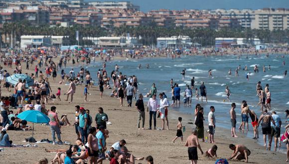 La gente toma el sol en la playa de Malavarrosa en Valencia el 24 de abril de 2023 mientras España se prepara para una ola de calor temprana.  (Foto de JOSE JORDANIA / AFP)