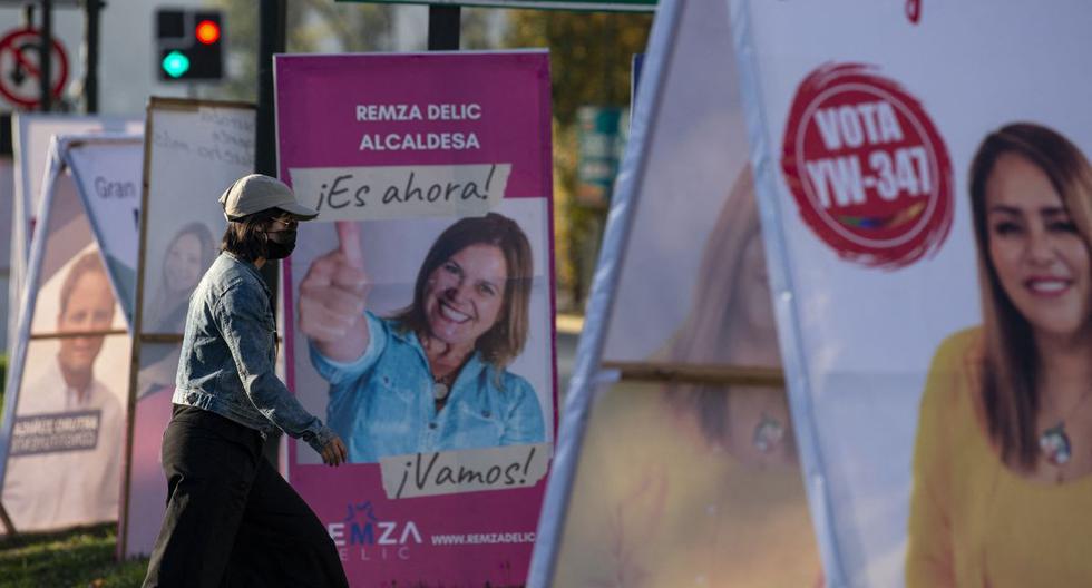Una mujer pasa por delante de la propaganda electoral en Santiago (Chile), el 12 de mayo de 2021. (MARTIN BERNETTI / AFP).
