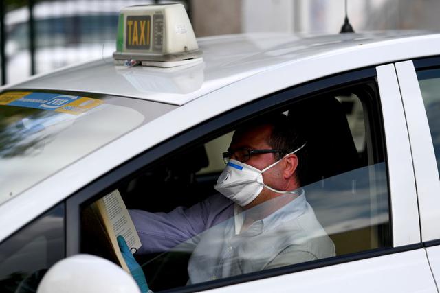Un taxista lee un libro mientras espera en su taxi en Madrid durante un cierre nacional para prevenir la propagación de la enfermedad COVID-19. (Foto: AFP/Gabriel Bouys)