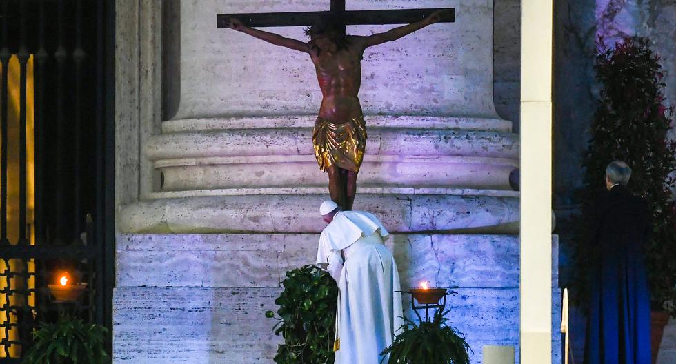 Pope Francis kisses a miraculous crucifix that in 1552 was carried in a procession around Rome to stop the great plague, that was brought from the San Marcello al Corso church in Rome, during a moment of prayer on the sagrato of St Peter�s Basilica, the platform at the top of the steps immediately in front of the fa�ade of the Church, to be concluded with the Pope giving the Urbi et Orbi Blessing, on March 27, 2020 at the Vatican. (Photo by Vincenzo PINTO / AFP)