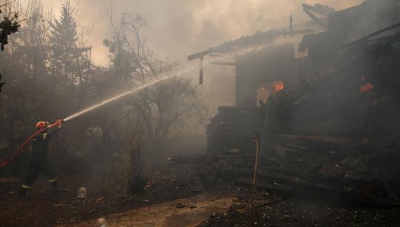 Un bombero combate un incendio que quema una casa en la zona de Afidnes, cerca de Atenas, Grecia, el 6 de agosto de 2021. (EFE/EPA/ALEXANDER BELTES).