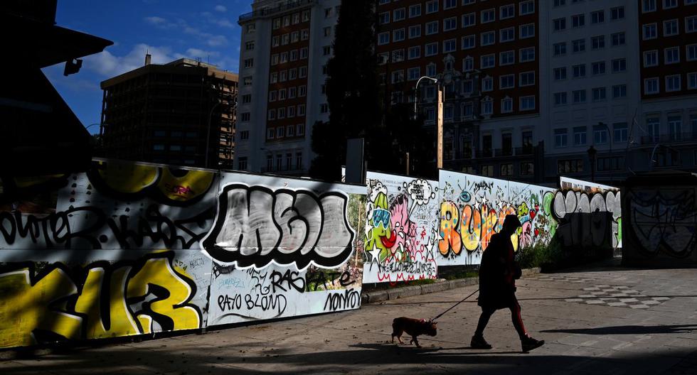 Imagen referencial. Una mujer pasea a su perro en la Plaza de España en Madrid, el 24 de abril de 2020. (Gabriel BOUYS / AFP).