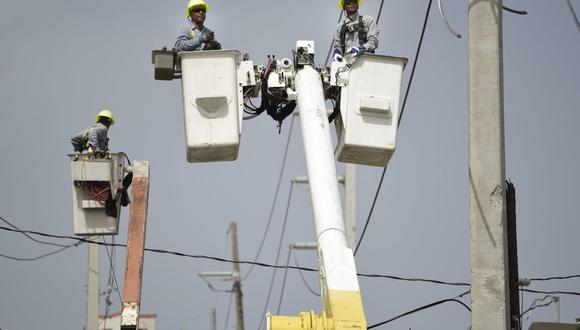 Los trabajadores de la Autoridad de Energía Eléctrica de Puerto Rico reparan las líneas de distribución dañadas en San Juan, el 19 de octubre de 2017. (AP/Carlos Giusti).