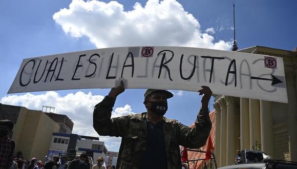 Un hombre sostiene un cartel que dice “Cuál es la ruta” y sin símbolos de bitcoins durante una protesta contra el presidente salvadoreño Nayib Bukele. (Foto: MARVIN RECINOS / AFP)