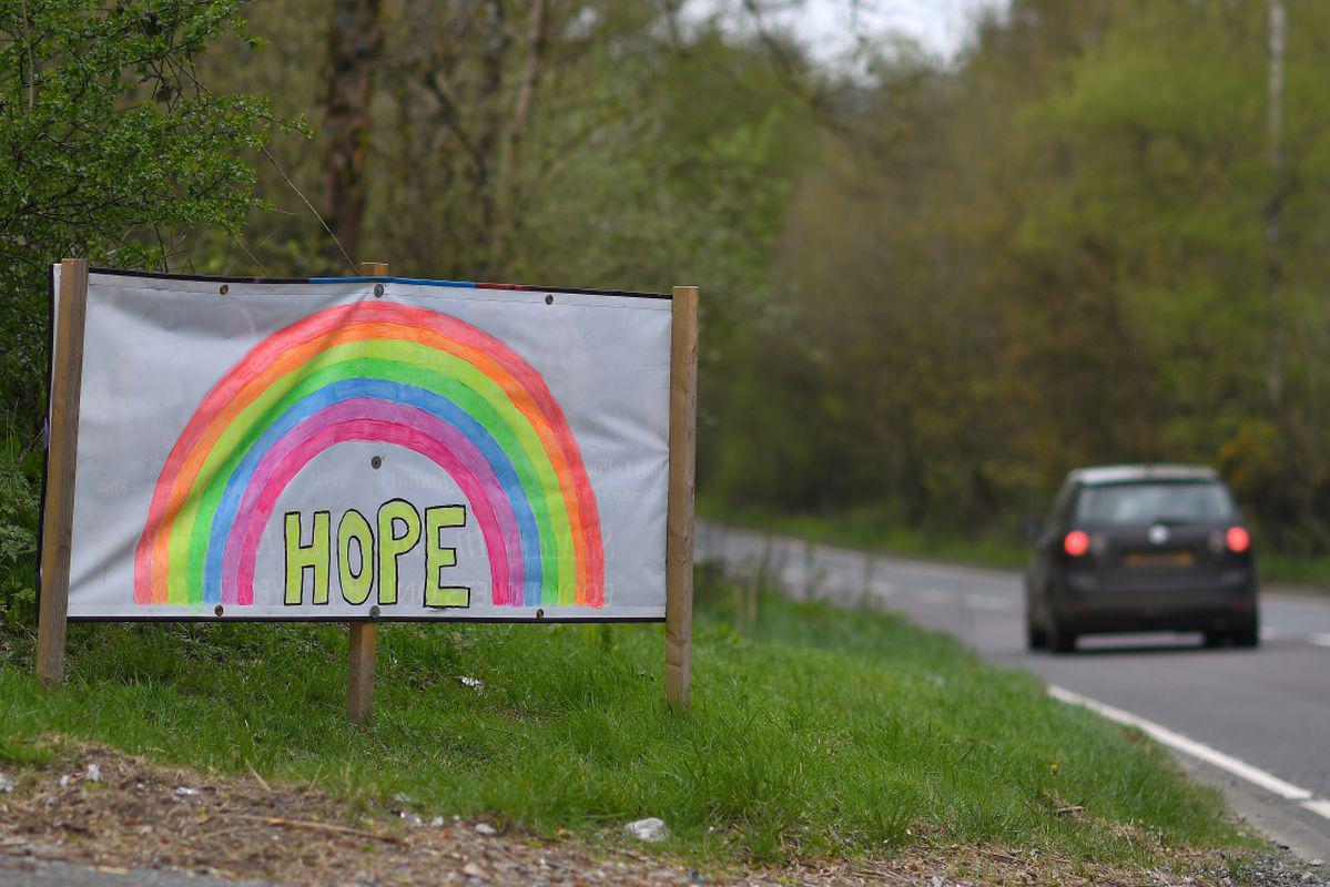 Un automóvil pasa una señal que representa un arco iris y la palabra "ESPERANZA", al costado de una carretera cerca de Lamberhurst, sureste de Inglaterra (Foto: Ben Stansall / AFP)