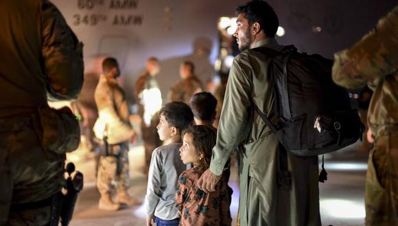 Imagen muestra a un padre afgano y a sus hijos evacuados el 24 de agosto de 2021. (Ryan BROOKS / US AIR FORCE / AFP).