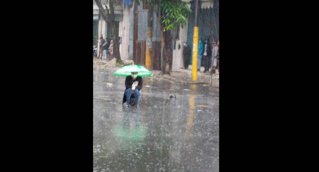 Iquitos: Responsable mujer soportó intensa lluvia y evitó aglomerarse con otras personas por COVID-19. (Foto cortesía: Iquitos al Rojo Vivo)