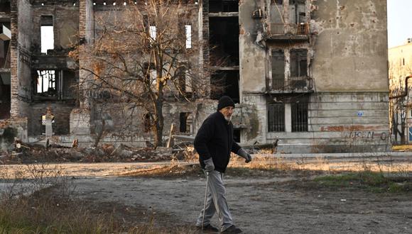Un residente local camina frente a un edificio residencial destruido en la ciudad de Lyman, región de Donetsk, el 14 de diciembre de 2022, en medio de la invasión rusa de Ucrania. (Foto de Genya SAVILOV / AFP)