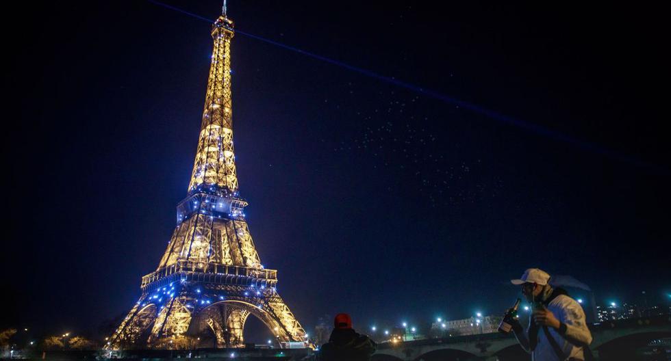 Imagen referencial. La gente bebe champán a orillas del Sena frente a la resplandeciente Torre Eiffel en París, Francia, el 1 de enero de 2021. (EFE/EPA/CHRISTOPHE PETIT TESSON).