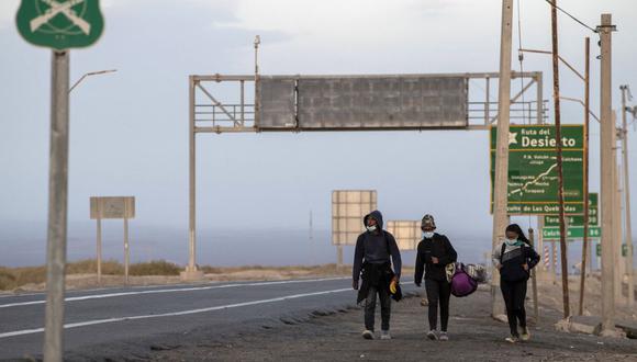 Venezolanos son vistos por la carretera camino a Iquique, luego de cruzar desde Bolivia, en Colchane, Chile, el 18 de febrero de 2021. (Martin BERNETTI / AFP).