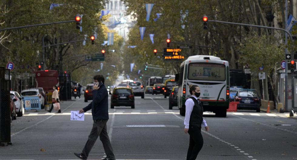 La gente cruza la Avenida de Mayo en Buenos Aires, el 28 de mayo de 2021, en medio de la pandemia de coronavirus. (Foto de JUAN MABROMATA / AFP).