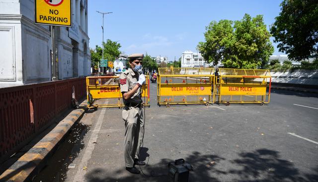 Un policía usa un altavoz para pedirle a las personas de Nueva Delhi, India que "se queden en casa". (AFP).