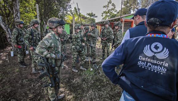 Soldados colombianos hablan con miembros de la Defensoría del Pueblo luego de ser liberados por campesinos en el municipio de Tibu. (Foto: SCHNEYDER MENDOZA / AFP)