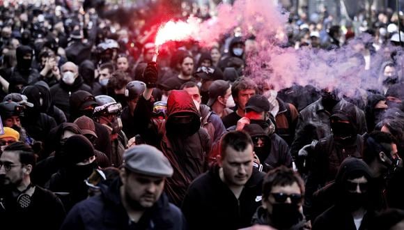 Los manifestantes encienden bengalas rojas mientras participan en la marcha anual del Primero de Mayo en París, Francia, el 1 de mayo de 2022. (Foto: EFE/EPA/YOAN VALAT)