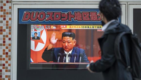 Un hombre pasa frente a una pantalla de televisión que muestra un informe de noticias sobre el último lanzamiento de un misil norcoreano con imágenes del líder norcoreano, Kim Jong Un, a lo largo de una pasarela peatonal en Tokio el 3 de noviembre de 2022. (Foto de Richard A. Brooks / AFP )