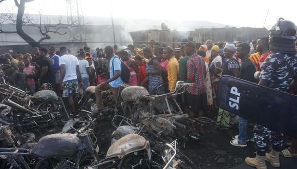 Los bomberos rocían agua en un contenedor quemado después de la explosión de un camión cisterna de combustible en Freetown (Foto: Saidu BAH / AFP)